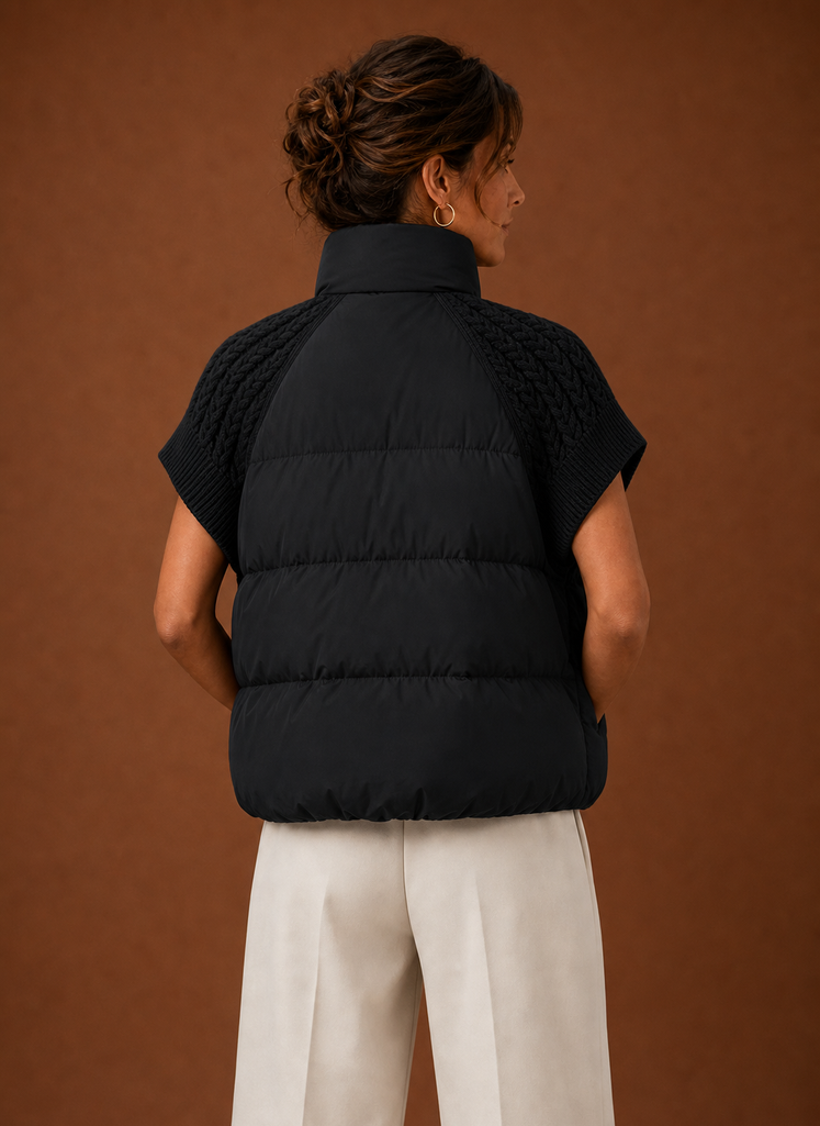 Women's black sleeveless puffer vest featuring stylish knit shoulder panels, perfect for layering in cool weather. 3