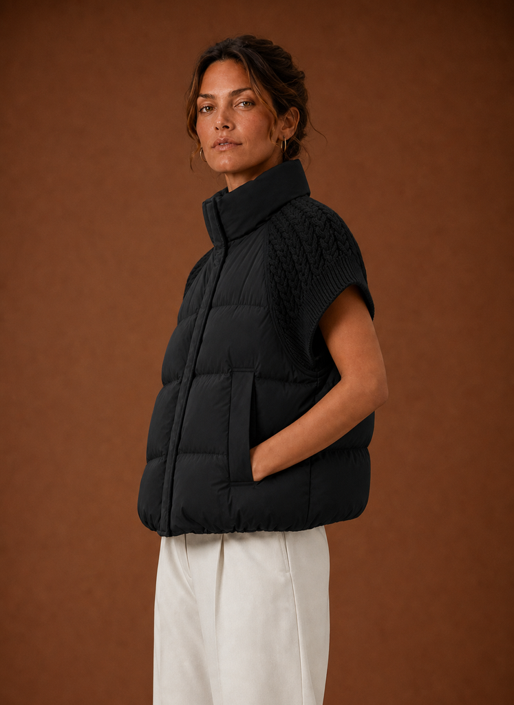 Women's black sleeveless puffer vest featuring stylish knit shoulder panels, perfect for layering in cool weather. 5